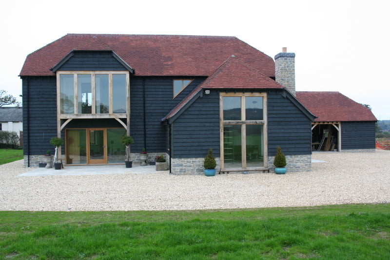 Barn-type building with larch cladding and large picture windows at front